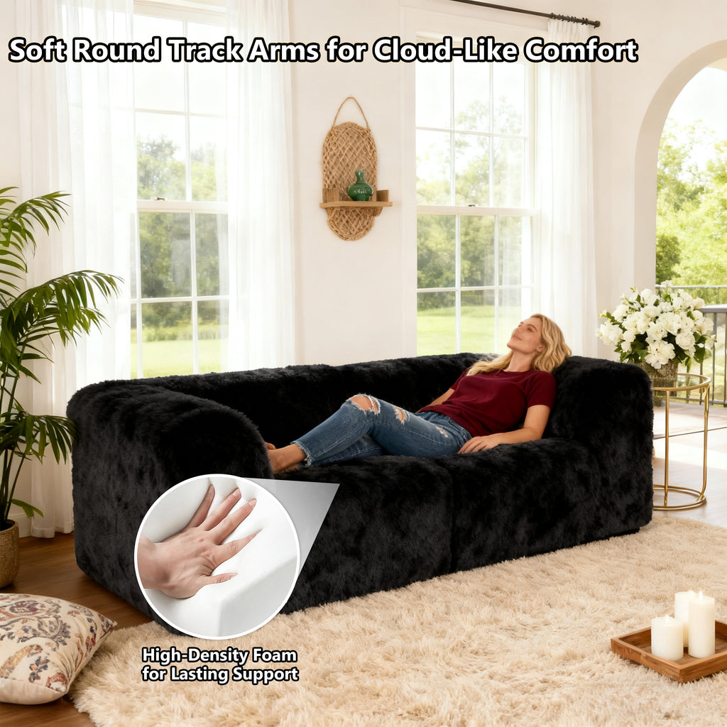 Black Modular Loveseat with its rounded armrests and high-density foam support – a lady is comfortably relaxing on the sofa