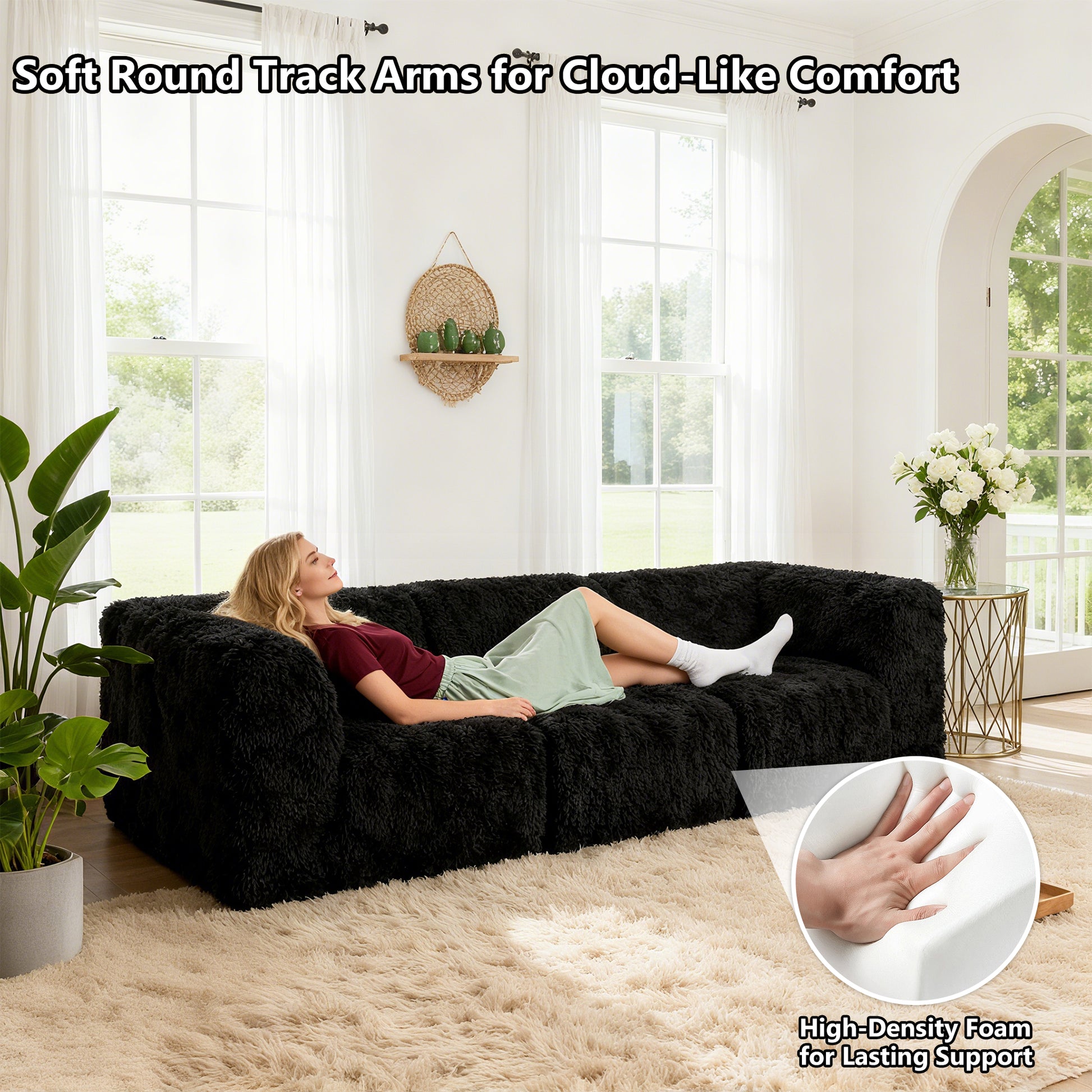 Black sofa with its rounded armrests and high-density foam support – a ladyis comfortably relaxing on the sofa.